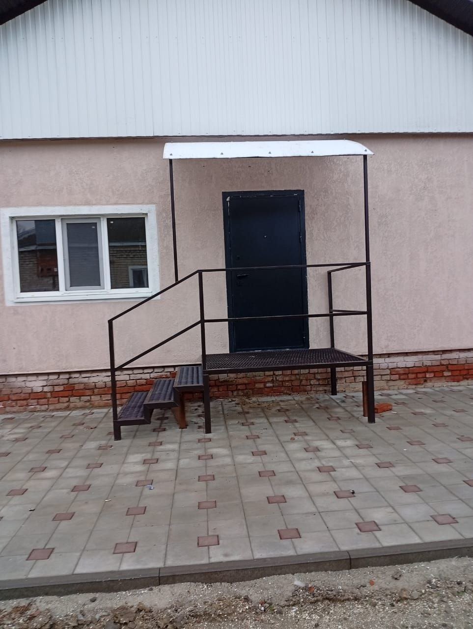 Входная дверь и металлическое крыльцо дома